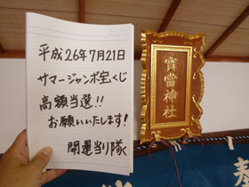 宝当神社の神額の横でサマージャンボ宝くじ高額当選のお願いを書いた記帳