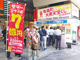 サマージャンボ1等7億円ののぼりの後ろは多くのお客さんで賑わっている有楽町駅大黒天売場