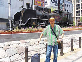 新橋駅前広場の蒸気機関車の前で記念撮影