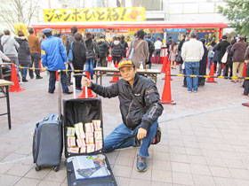大阪駅前第４ビル特設売場の前で今日買った年末ジャンボ宝くじをバックに詰めて記念撮影